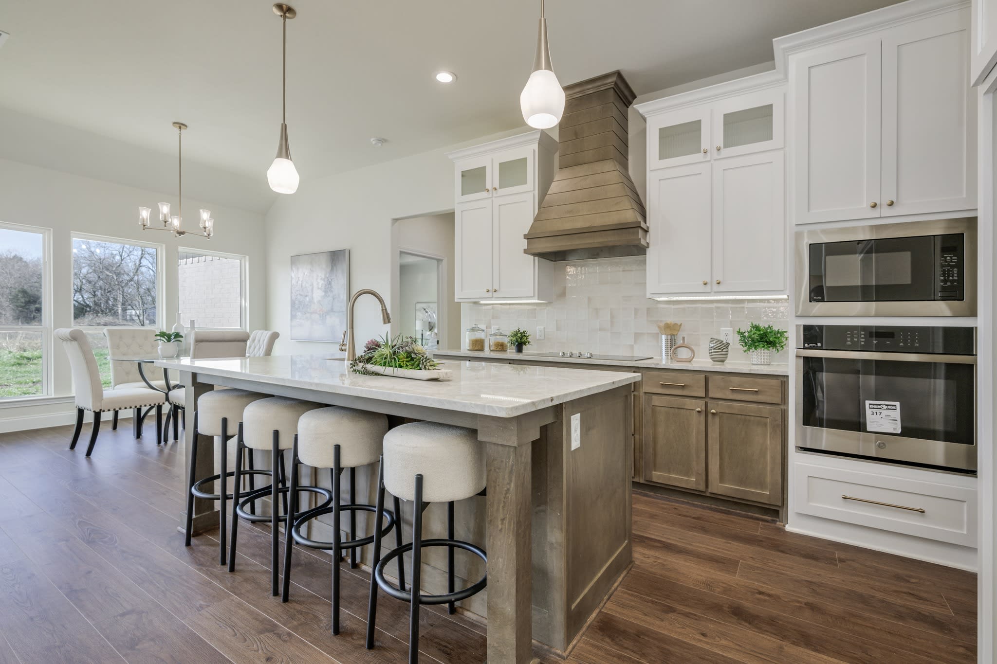 Renovated kitchen with island seating, mixed cabinetry, and pendant lighting